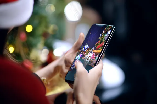 A player using their smartphone during a festive local event, representing CD444’s fully mobile-friendly casino.